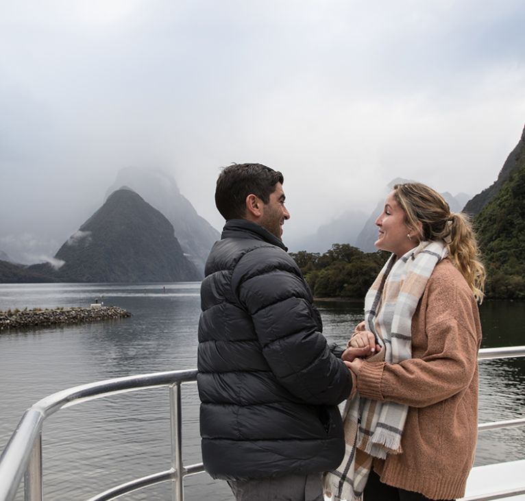 Visiting Milford Sound in Winter Couple enjoying stunning views of Milford Sound