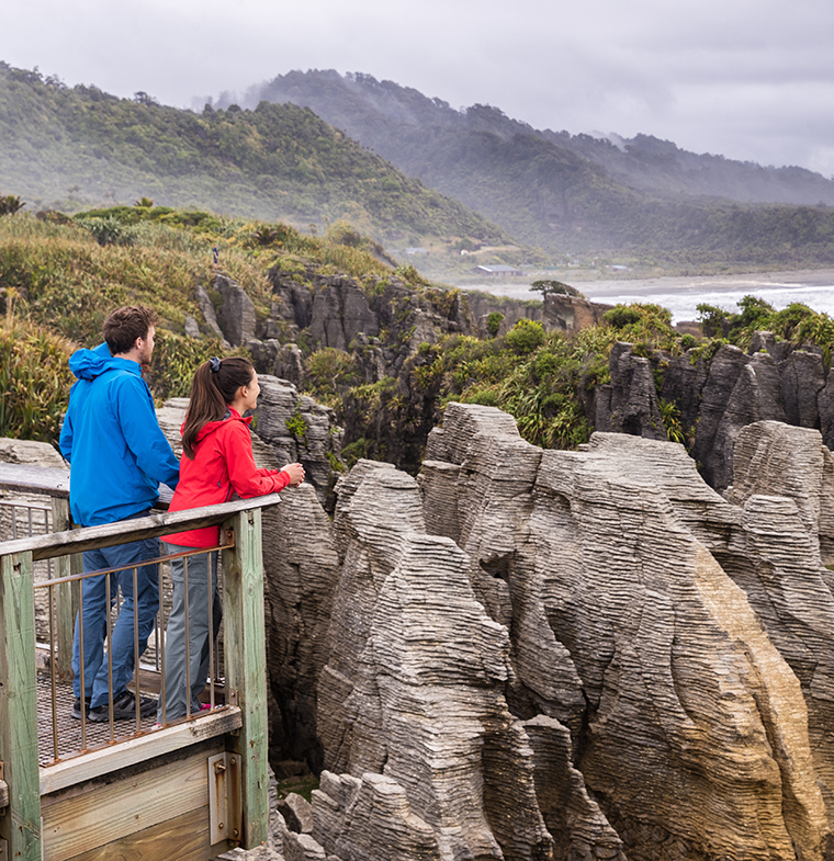 Things to do in Queenstown when the Milford Road is closed Punakaiki Pancake Rocks tourists couple travel in Paparoa National Park